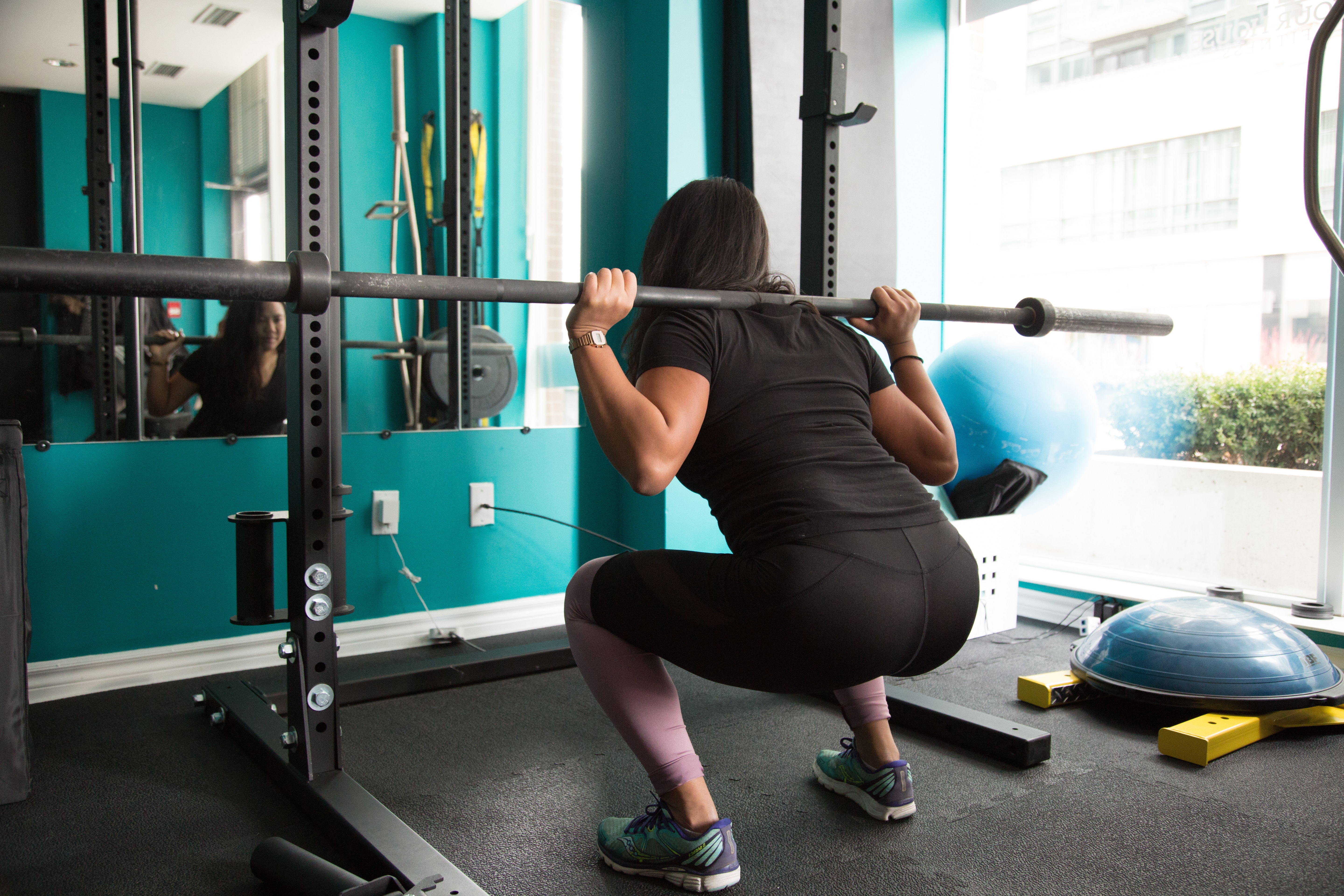 woman squatting with a barbell