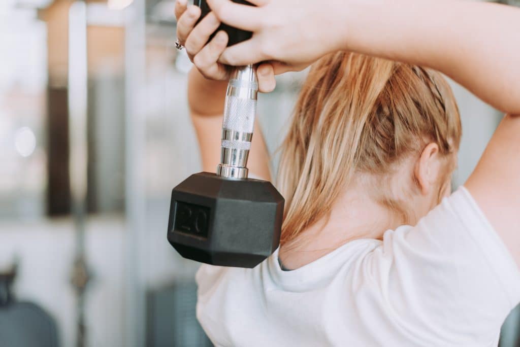 girl working her arms at a gym