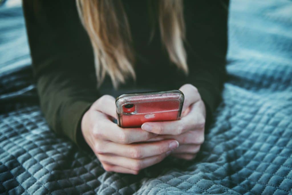 a woman scrolling social media on her phone