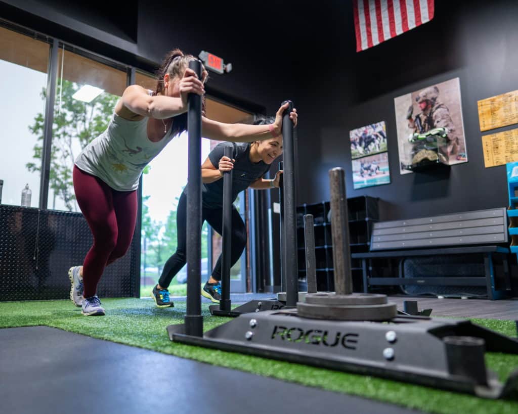 Amy and Megan pushing sleds at Beyond Strength in Sterling, Virginia
