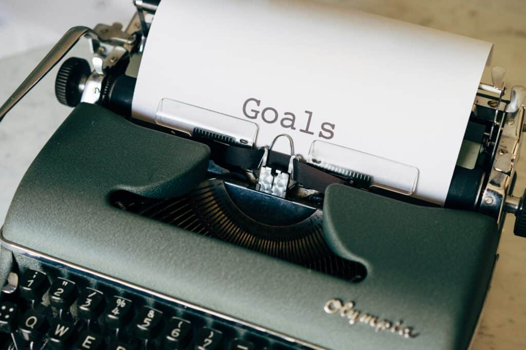 A typewriter with which someone is beginning to write their goals.